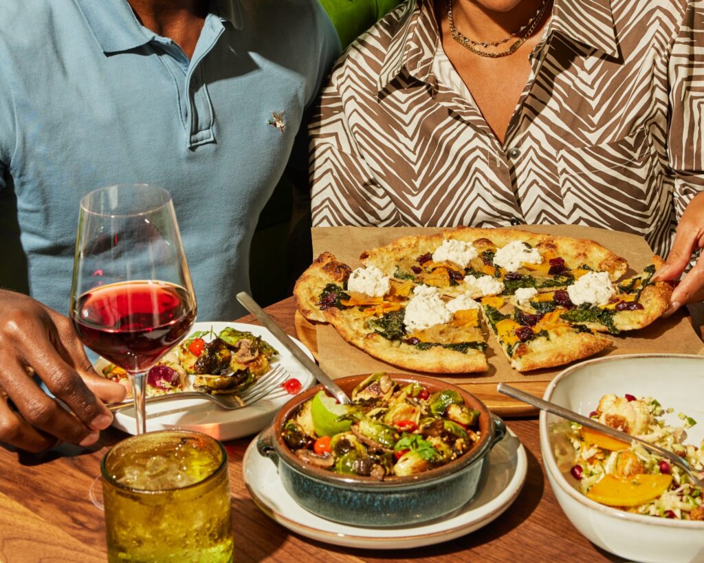 spread of food and wine with couple in background