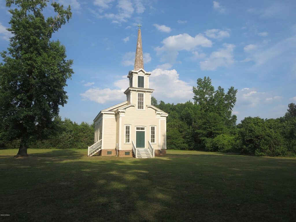 small church with steeple surrounded by trees