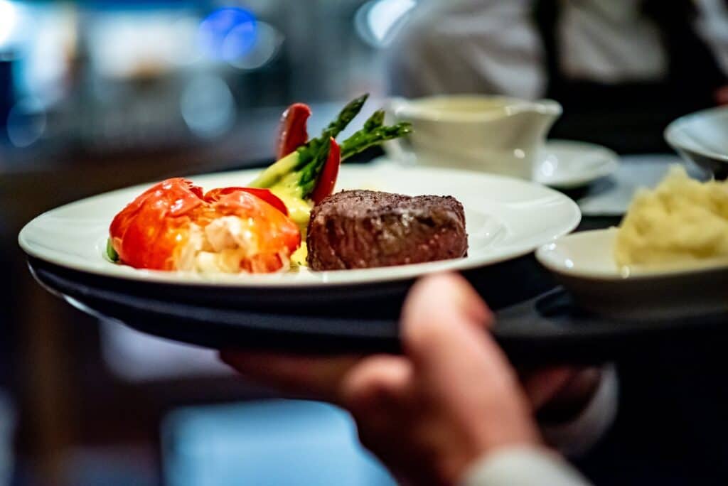 waiter carrying surf and turf