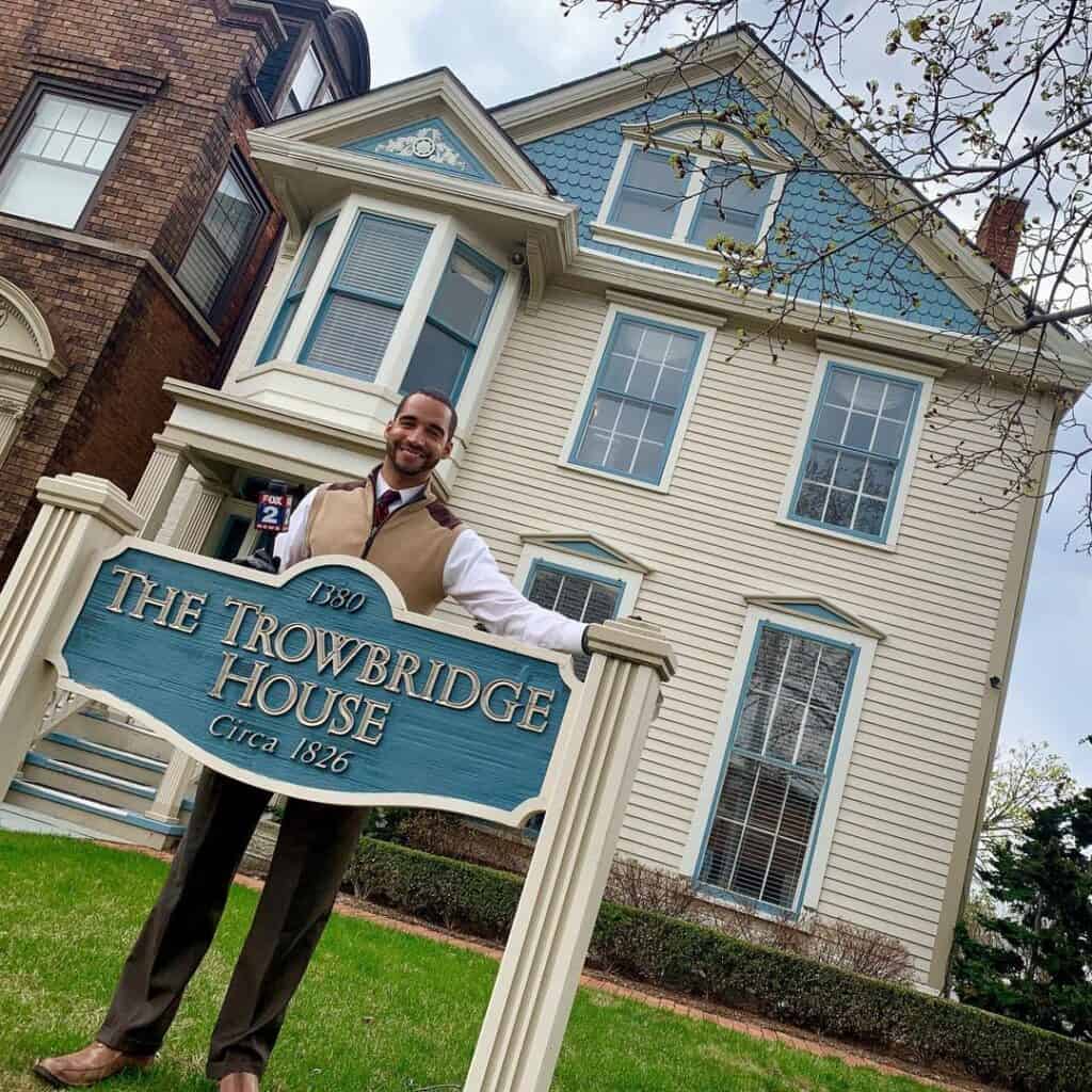 Man posing by Towerbridge House sign