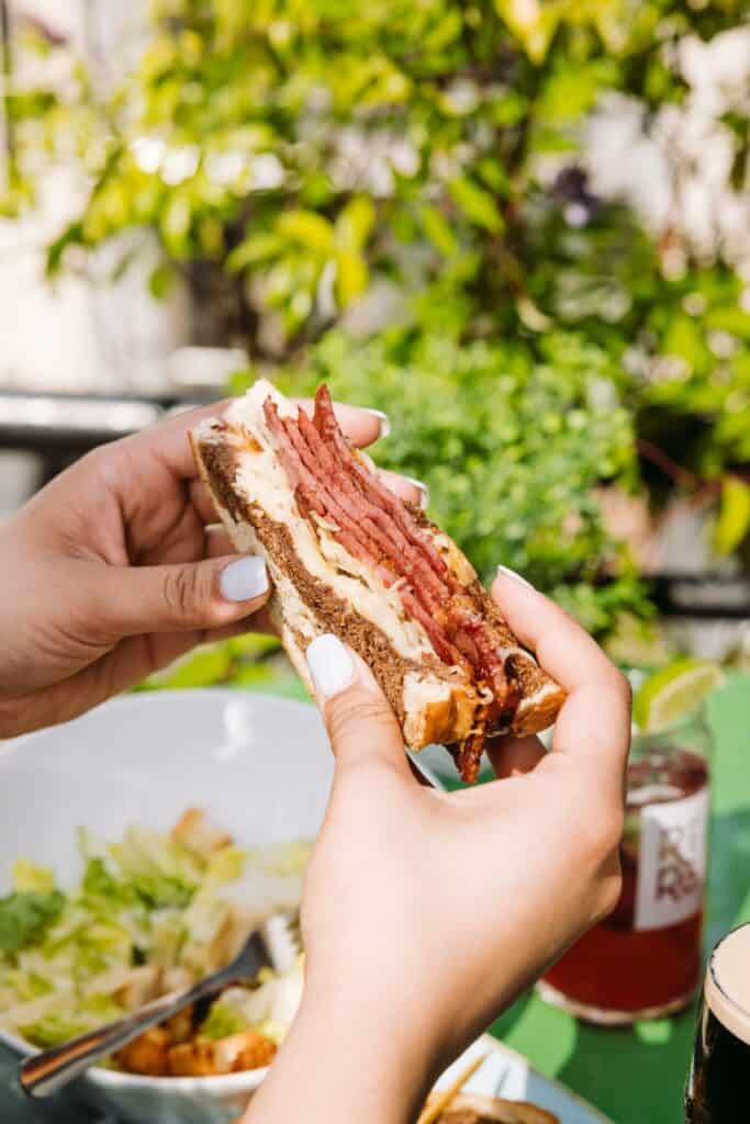 hand holding Reuban sandwich