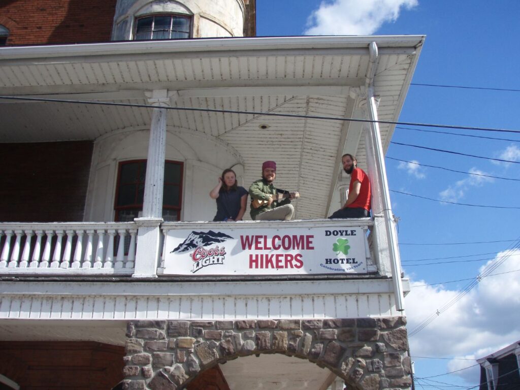 people on balcony by Welcome Hikers sign