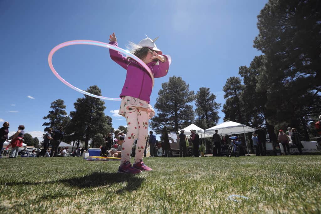 A child hula hooping at an Earth Day event hosted by the City of Flagstaff City of Flagstaff x